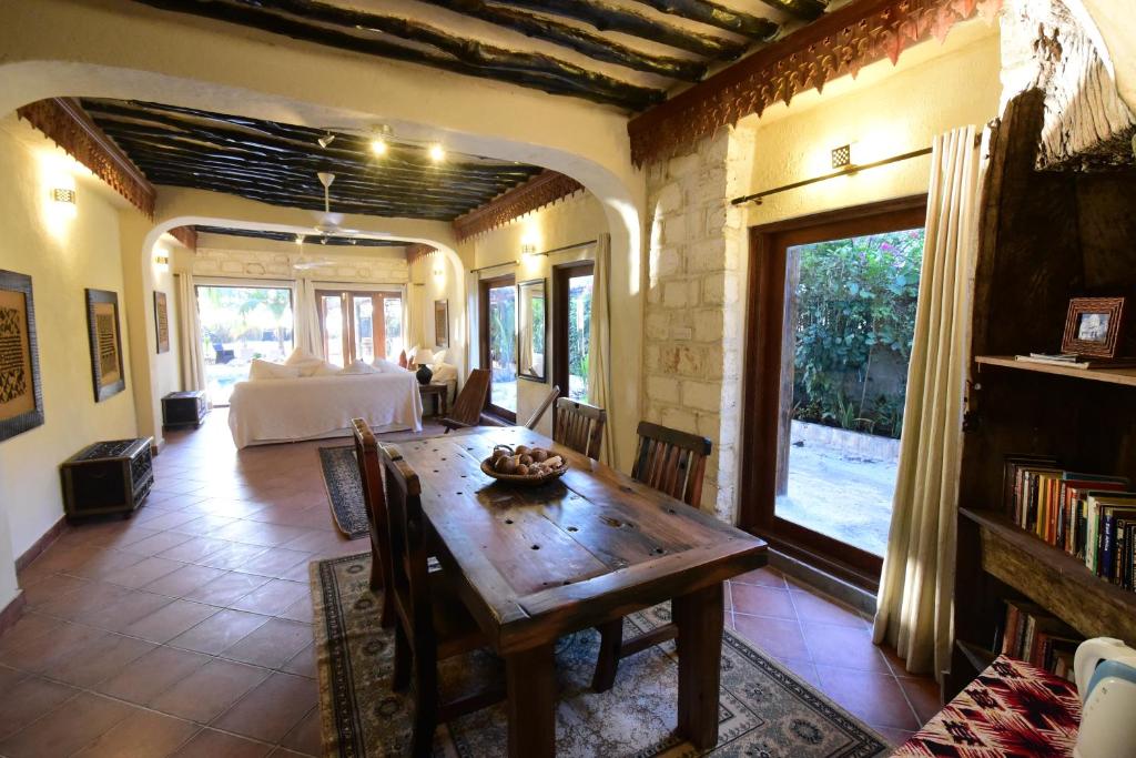 a living room with a wooden table and a couch at Tamani Villas in Matemwe