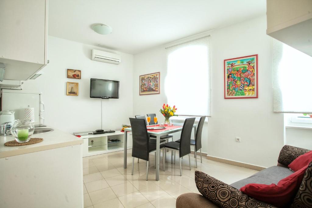 Apartment Bose في سبليت: مطبخ وغرفة معيشة مع طاولة وكراسي