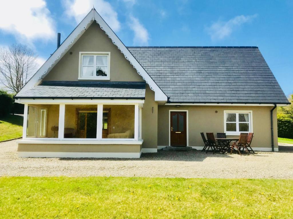 une maison avec une table et des chaises devant elle dans l'établissement The-Gables, à Donegal