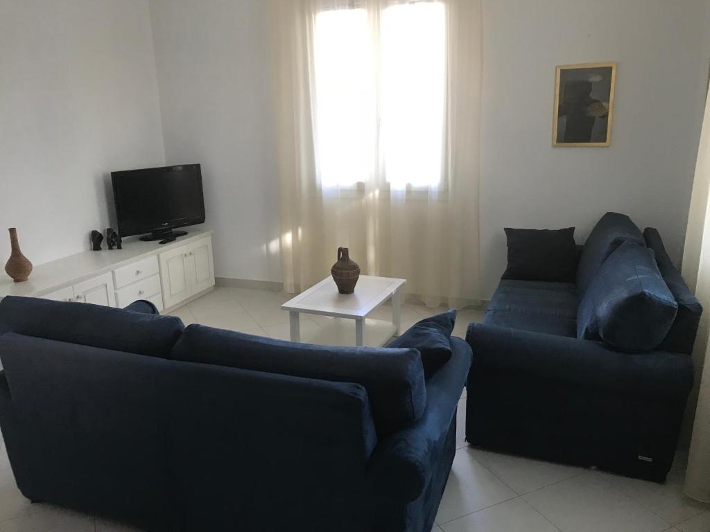 een woonkamer met twee blauwe banken en een tv bij Casa Gigi in Olbia