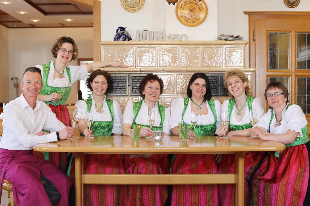 een groep mensen die aan een tafel zitten bij Hotel-Restaurant Gasthof Adler in Neuenburg am Rhein