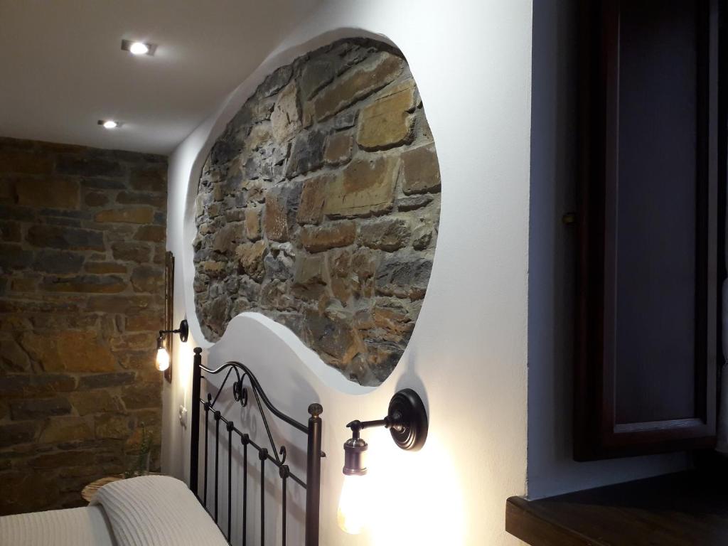 a room with a stone wall with a crib and lights at La Corrala de Jose Susana in San Miguel