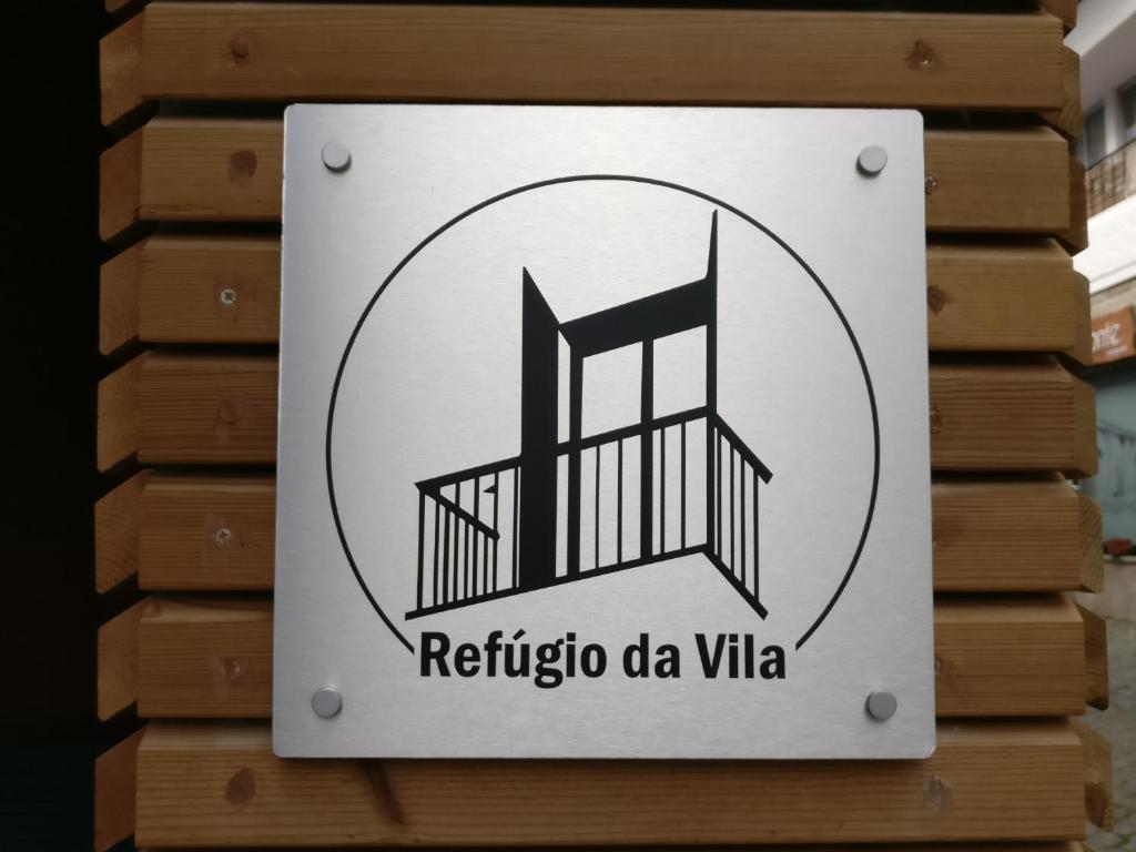 沃澤拉的住宿－Refúgio da Vila - Refuge of the Village，墙上的回达维塔的标志