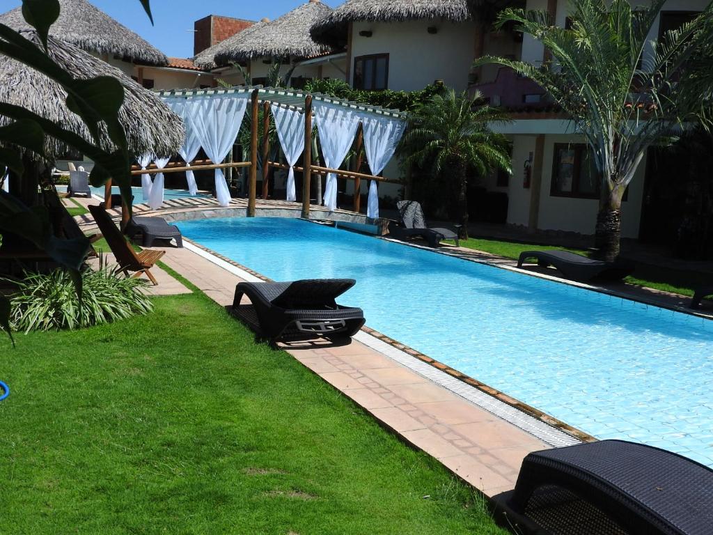 einen Pool mit Liegestühlen in einem Resort in der Unterkunft IL Nuraghe in Canoa Quebrada