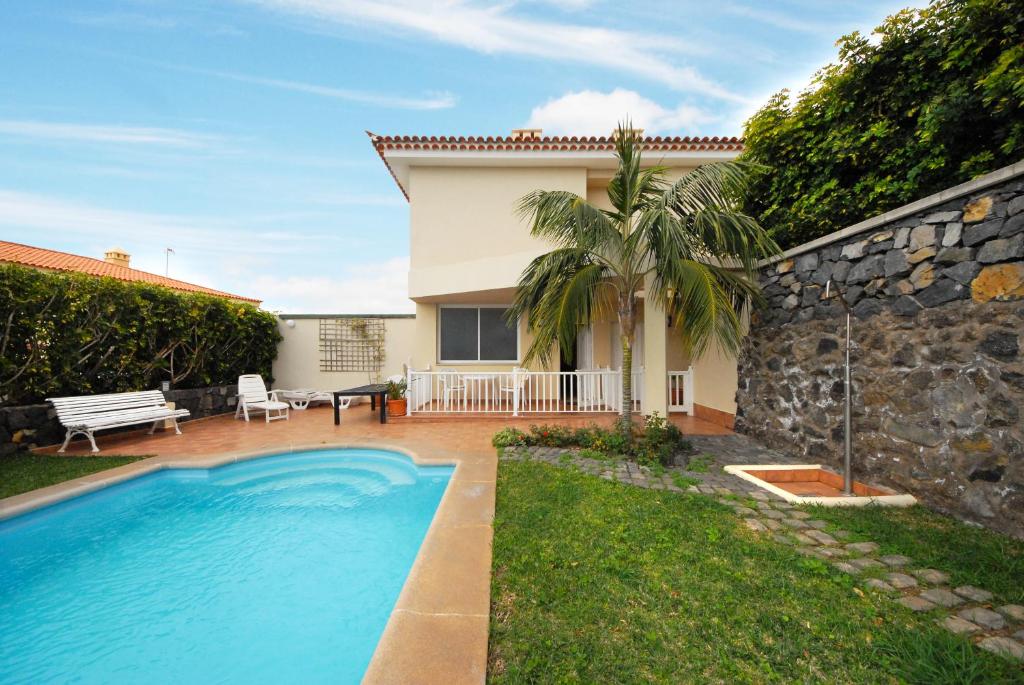 a villa with a swimming pool and a house at Azalea - vivienda vacacional in Puerto de la Cruz