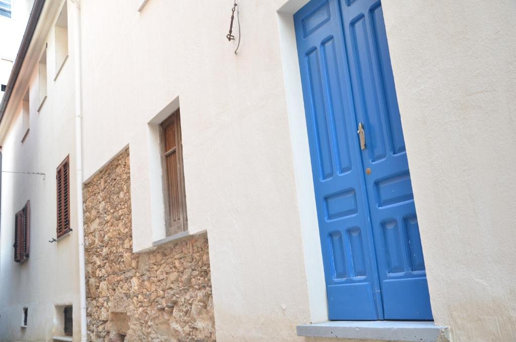 una puerta azul en el lateral de un edificio en Guest House Sa Succargia en Baunei