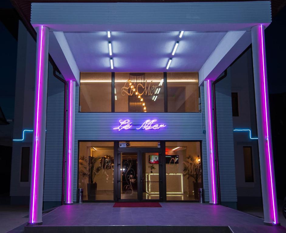 a building with purple lights in front of it at Le Mer in Afumaţi