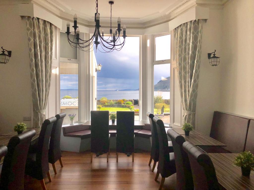 a dining room with a table and chairs and a large window at St Ives Boutique Hotel in Dunoon