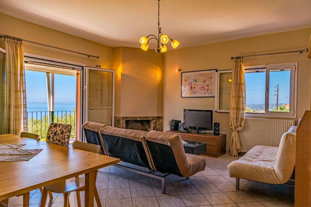 ein Wohnzimmer mit einem Tisch und einem Esszimmer in der Unterkunft Ioannis House Sea View in Lourdata