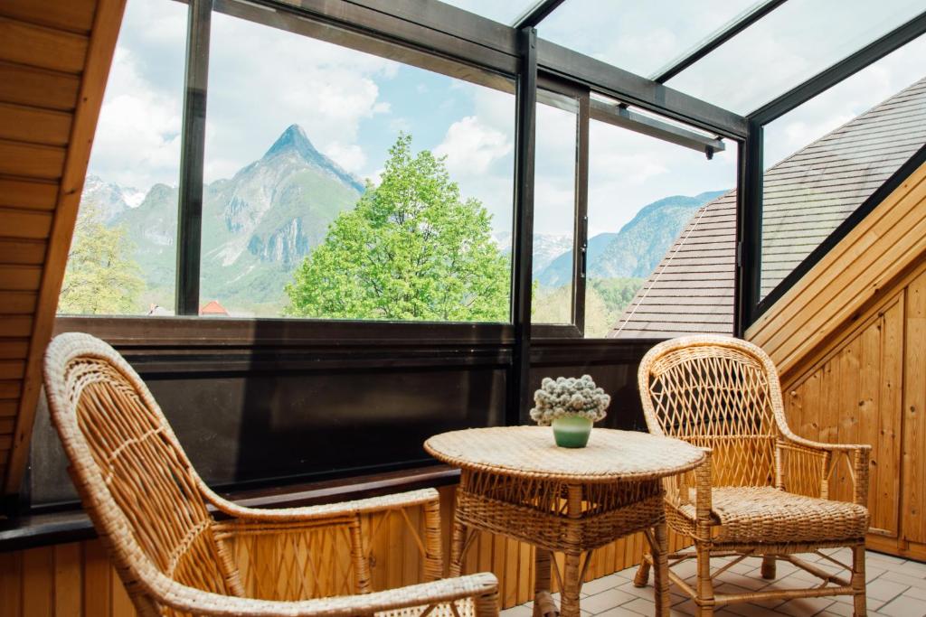 a balcony with a table and two chairs and a large window at Apartment Bor in Bovec