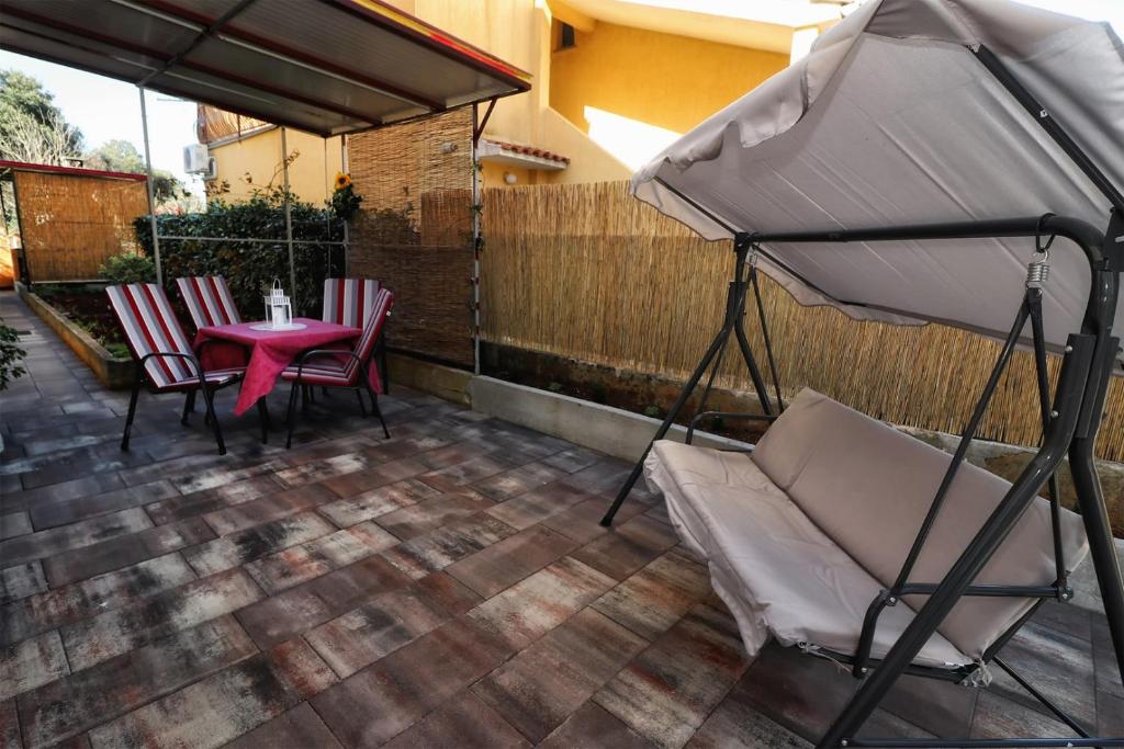 een patio met een tafel en stoelen en een parasol bij Apartment Edi in Pula