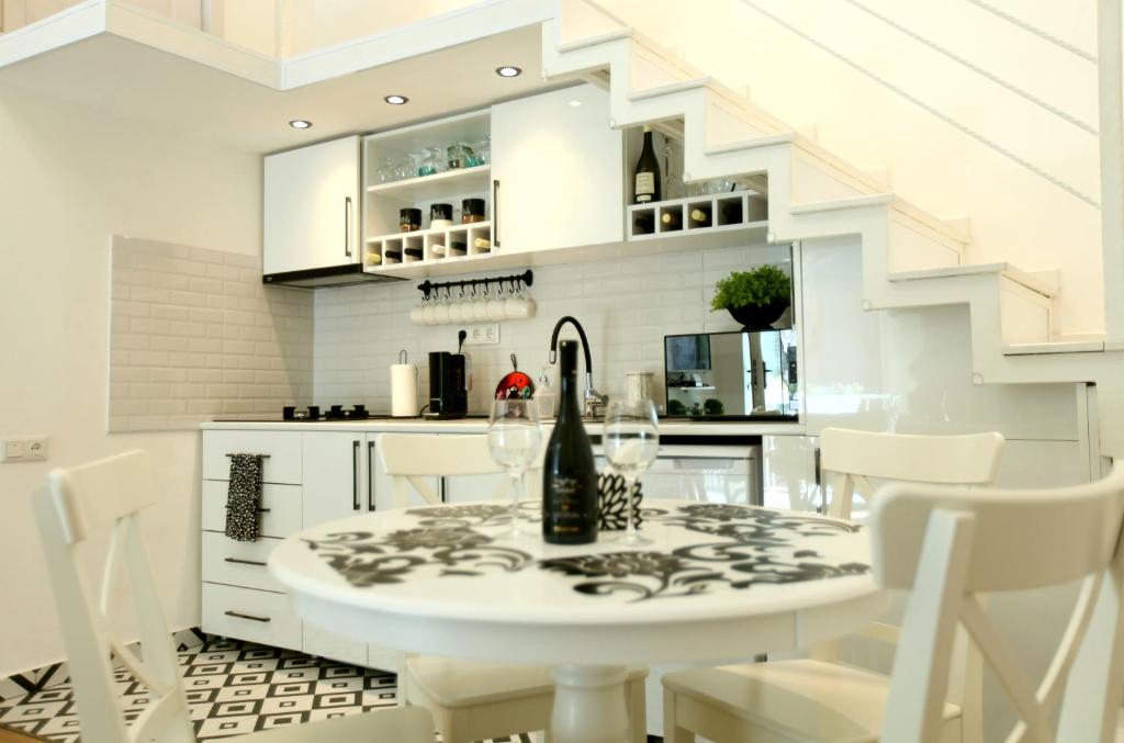 una cucina bianca con tavolo bianco e sedie bianche di Diplomat Apartment a Tbilisi City