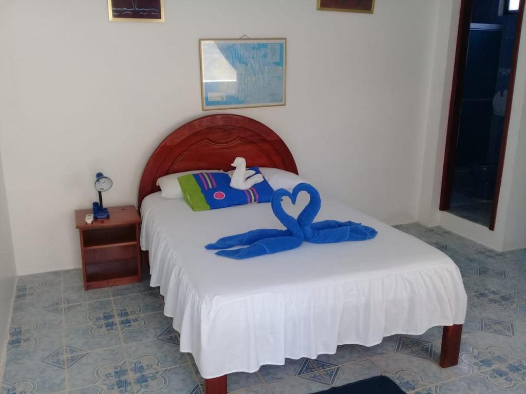 a bedroom with a bed with a blue swan on it at Hostal Insular in Puerto Villamil