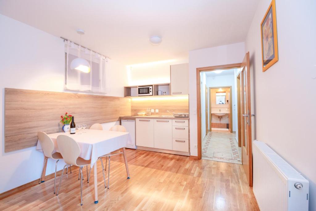 eine Küche und ein Esszimmer mit einem weißen Tisch und Stühlen in der Unterkunft Alp Apartma in Radovljica