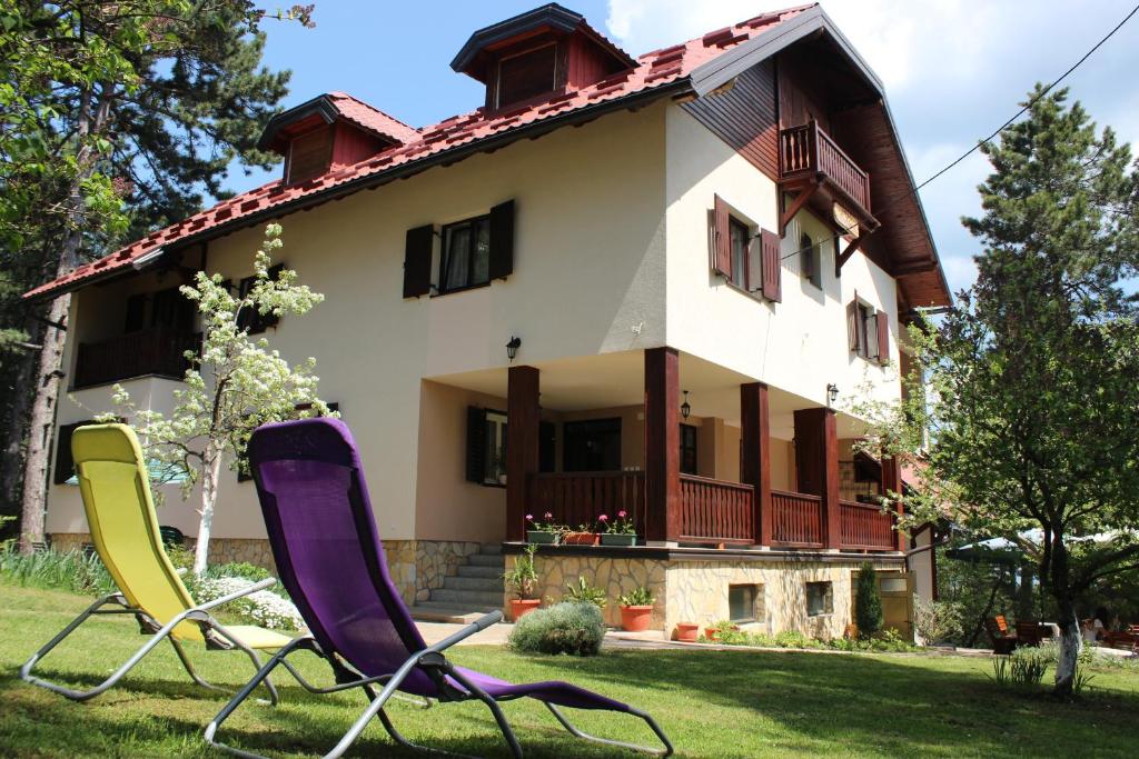 una casa con dos sillas de jardín delante en Guest House 3M, en Kaludjerske Bare