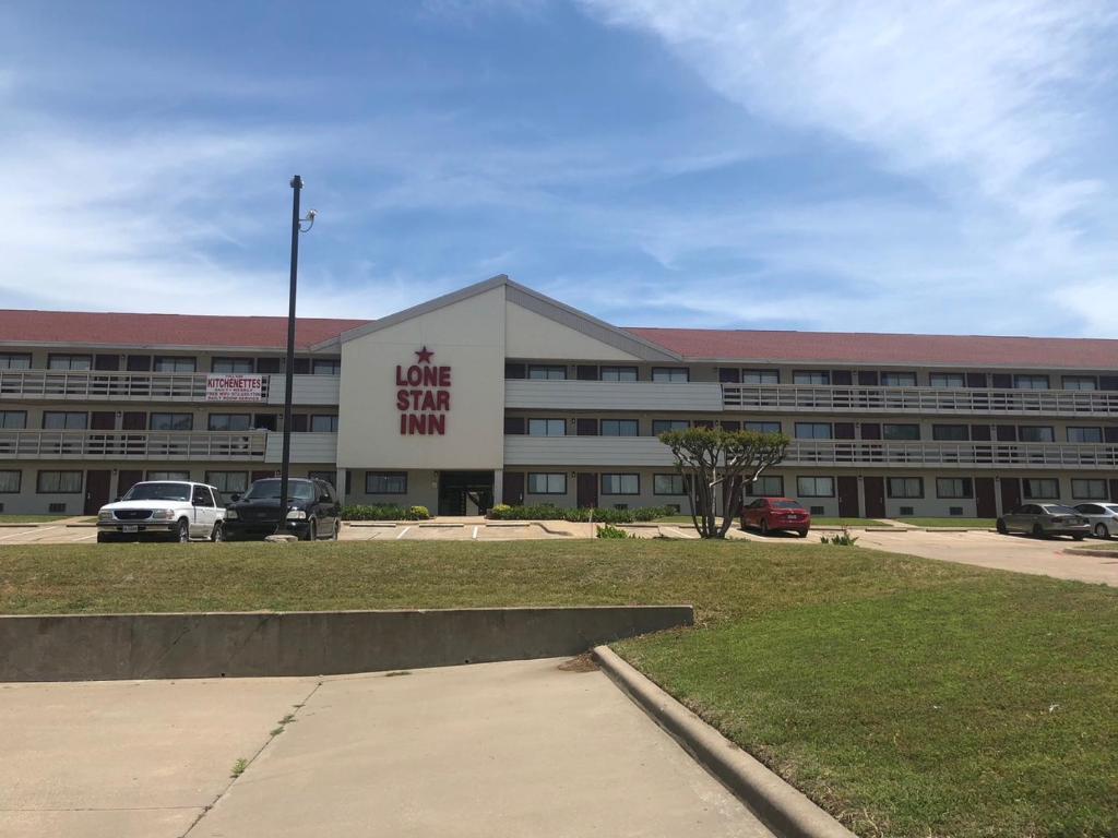 a large building with a sign that reads love sign him at Lone Star Inn in Carrollton