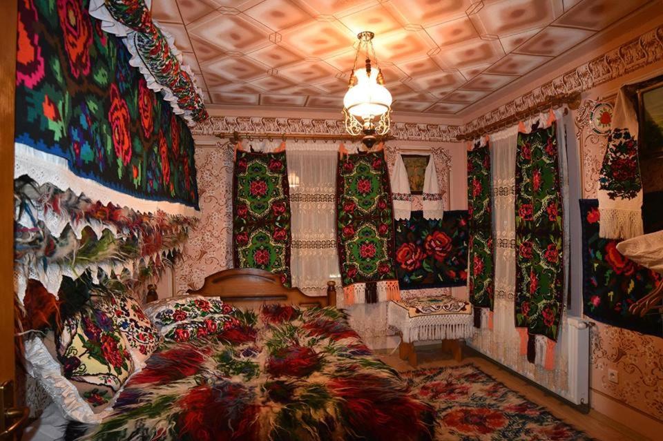 a bedroom with a large bed and christmas curtains at Pensiunea Valea Branzei in Năneşti
