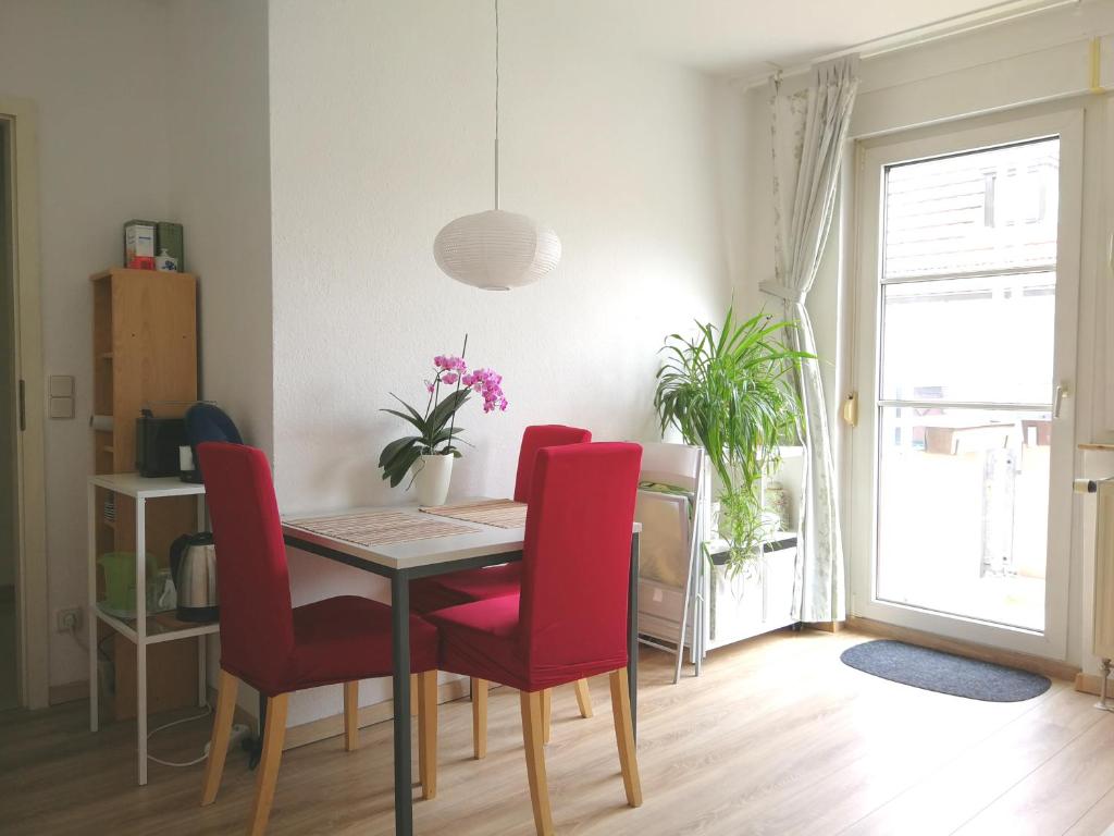 uma sala de jantar com uma mesa e cadeiras vermelhas em Quiet City-Apt, 4min City-Center, 18min Fair Nürnberg!!! em Nurembergue