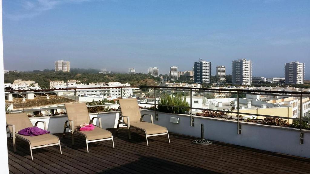 a balcony with chairs and a view of a city at Alvor Ria Apartment in Alvor