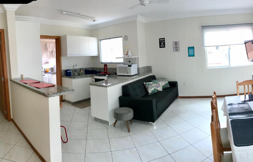 cocina y sala de estar con sofá y mesa en Apartamento Água Verde, Rua 263, en Itapema