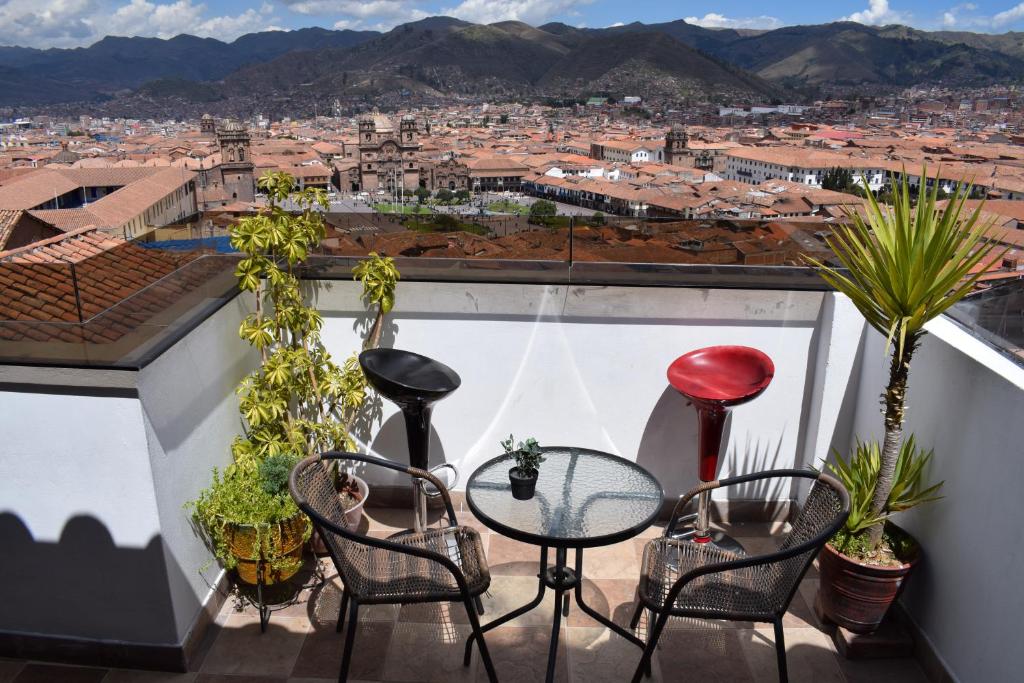 Un balcón con sillas y una mesa con vistas. en Hostal Casa Del Inka, en Cusco