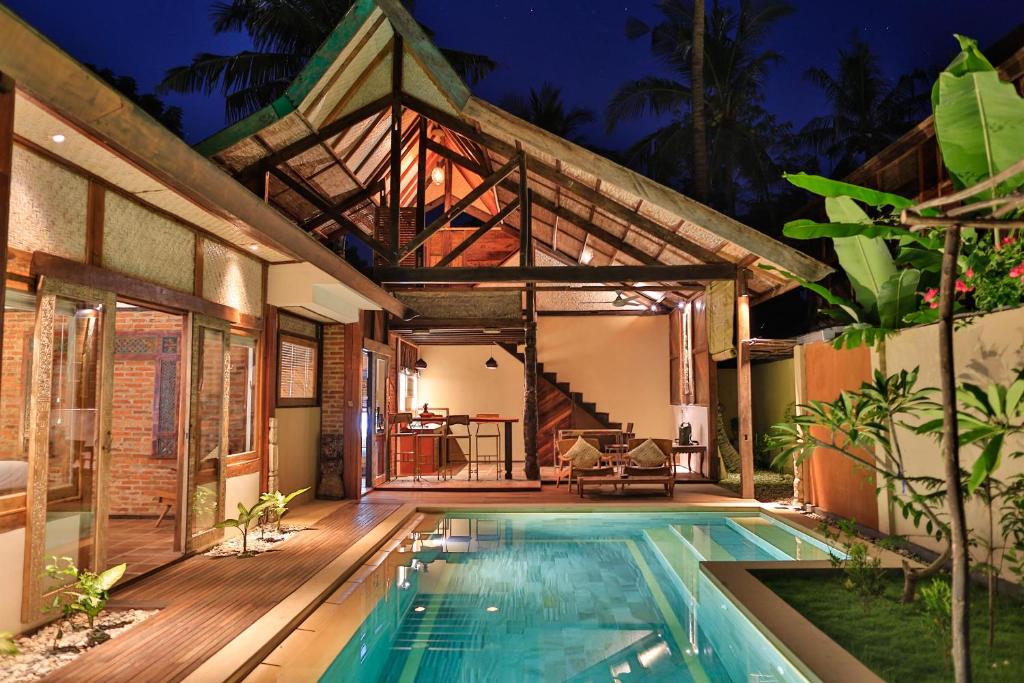 a house with a swimming pool and a patio at Apalagi Villas in Gili Air