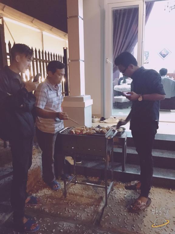 Un gruppo di persone che si aggirano intorno a un tavolo con un agente di polizia di Villa Tường Vy - Đà Lạt a Da Lat