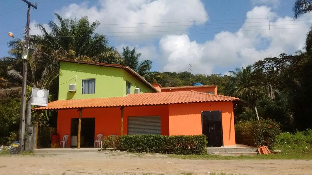 a house with an orange yellow and green at Pousada Luar de Monte Cristo in Araripe de Baixo