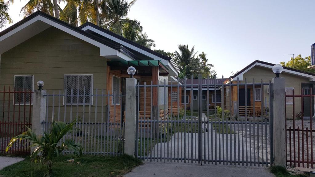 una casa con una puerta y una valla en Honeybee apartments, en Bantayan Island