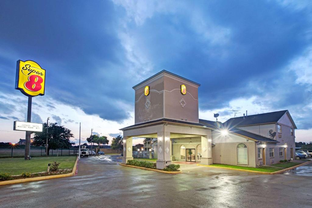 un edificio con un cartel en un estacionamiento en Super 8 Dallas-Mesquite, en Dallas