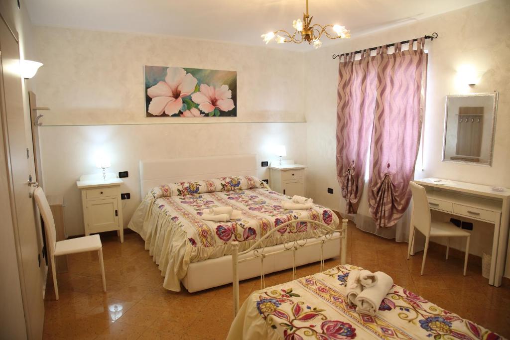 sypialnia z 2 łóżkami, biurkiem i lustrem w obiekcie À La Maison De Gabry w mieście Vibo Marina