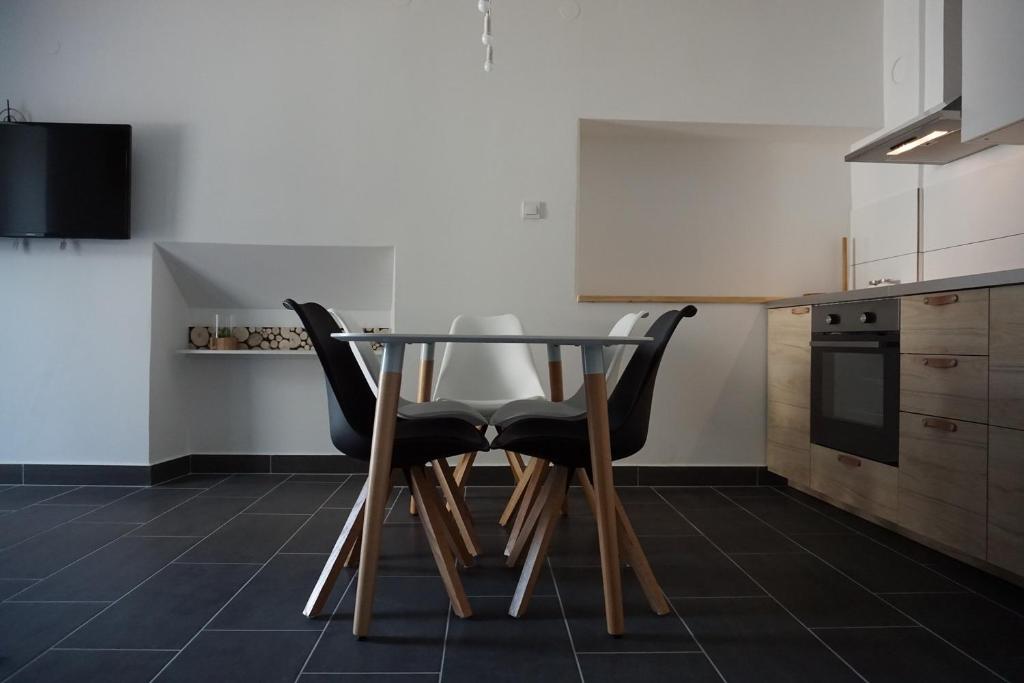 een eettafel met 2 stoelen in een keuken bij Corner Apartments in Bovec