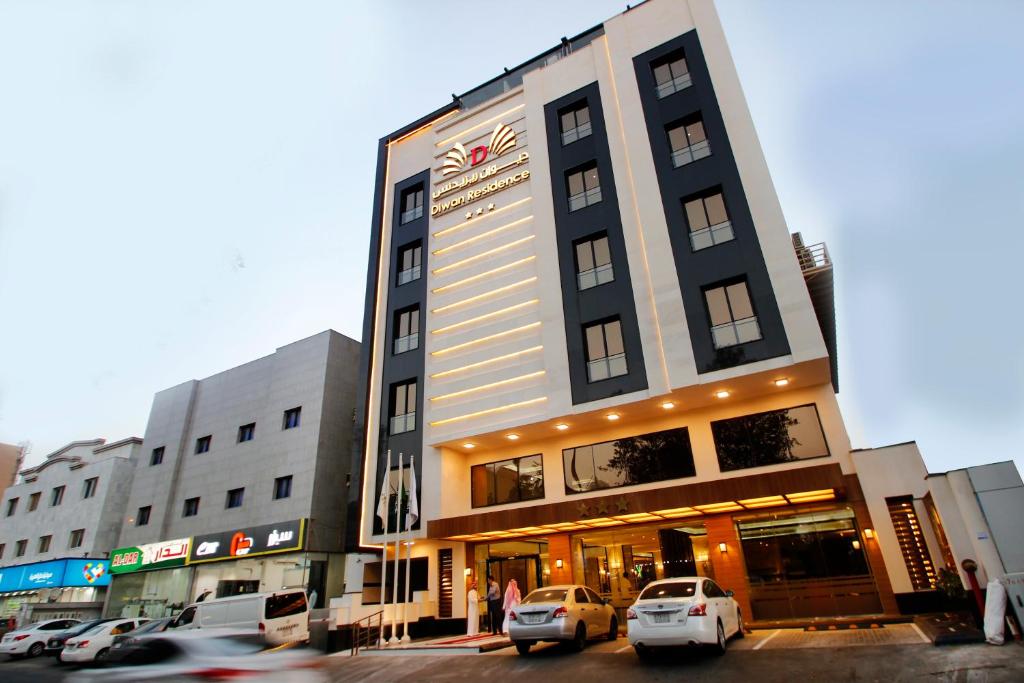 فندق مسكن ديوان - النعيم في جدة: مبنى طويل وبه سيارات متوقفة أمامه
