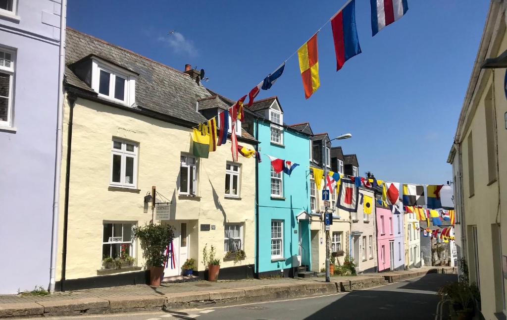 a row of colorful houses on a street with flags at Cyntwell Guest Accommodation in Padstow