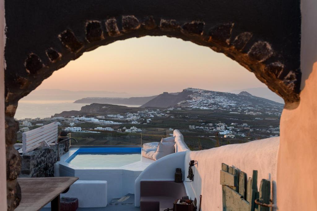 a view through an archway of a villa with a pool at Phaos 1870, A restored Winery in Pyrgos