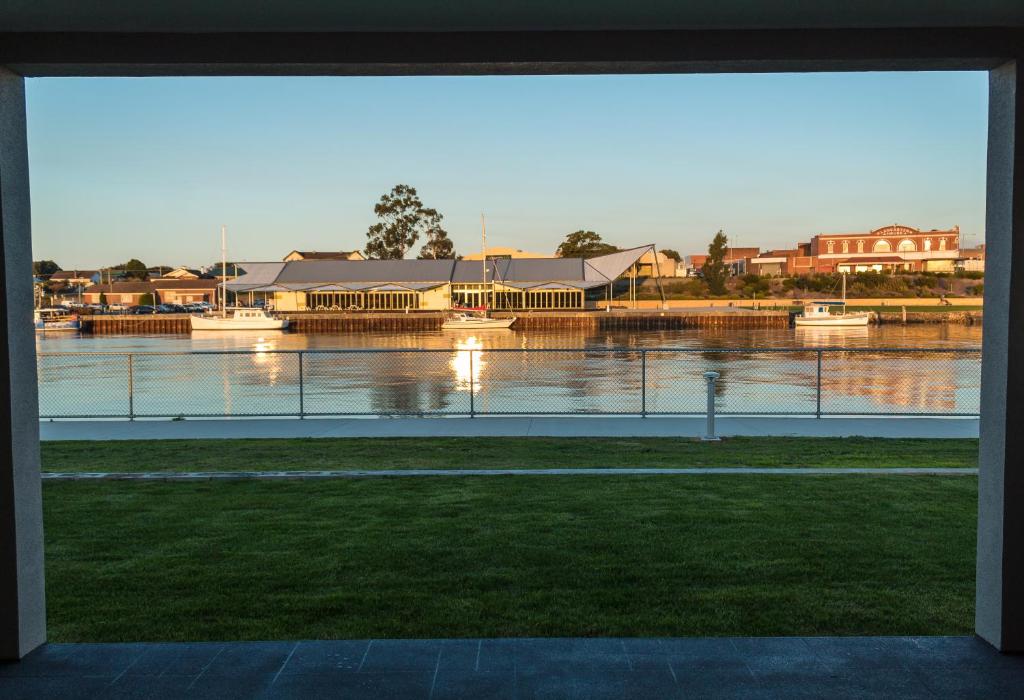 a lake with a view of a city and houses at Ulverstone Waterfront Apartments in Ulverstone