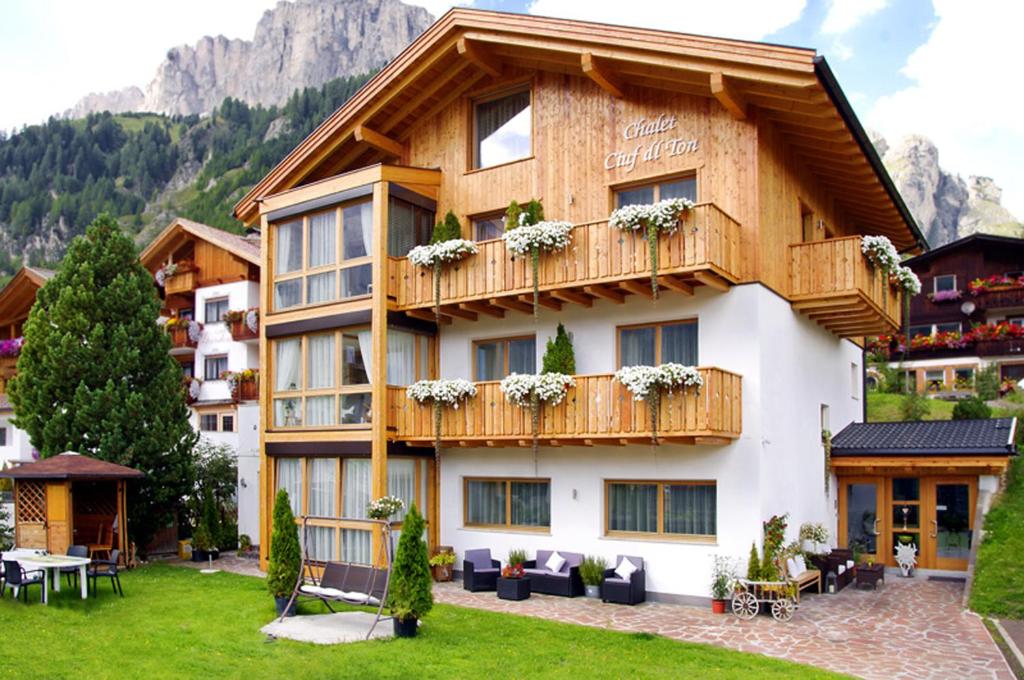 ein großes Apartmenthaus mit Balkon und Rasen in der Unterkunft Apartments Chalet Ciufdlton in Kolfuschg