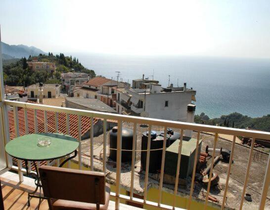 a balcony with a table and a view of the ocean at Pansion Alexandros in Pelekas