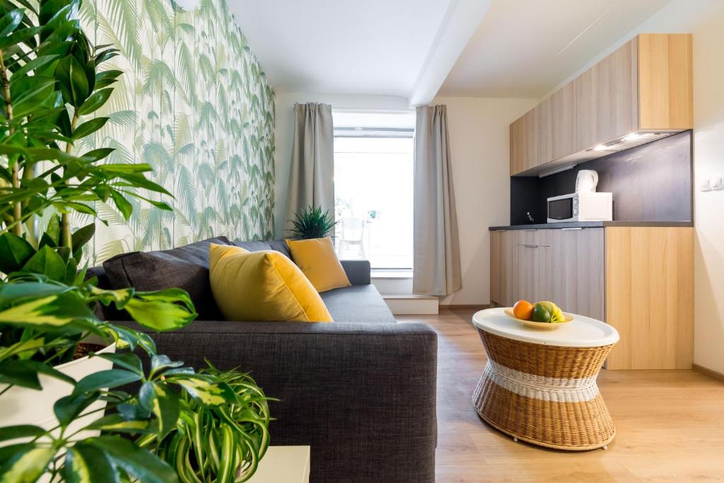 ein Wohnzimmer mit einem Sofa und einem Tisch in der Unterkunft Cosy Green Oasis in city center in Zagreb