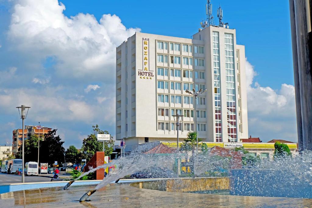 una fuente de agua frente a un edificio en Rozafa Hotel en Shkodër