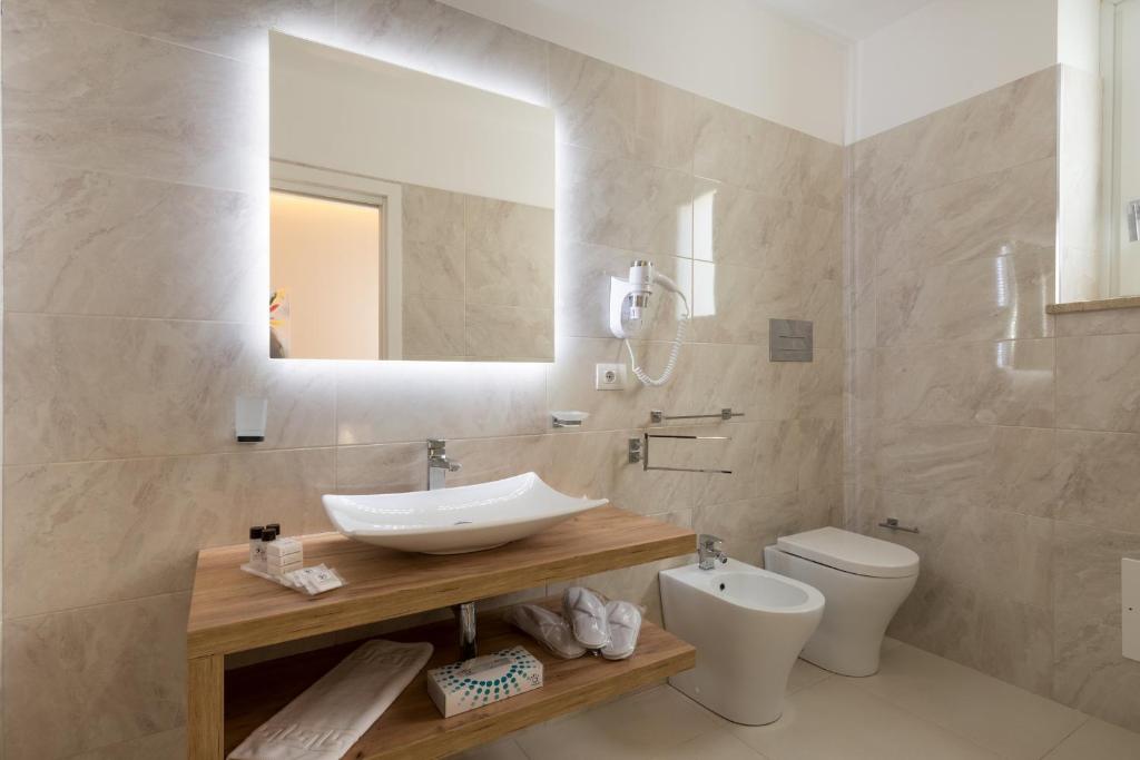 a bathroom with a sink and a toilet at Artemide Hotel in San Vito lo Capo
