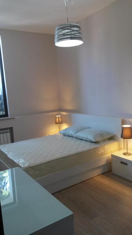 sypialnia z łóżkiem z 2 lampami w obiekcie City View Apartment on Gorgiladze 1 w mieście Batumi