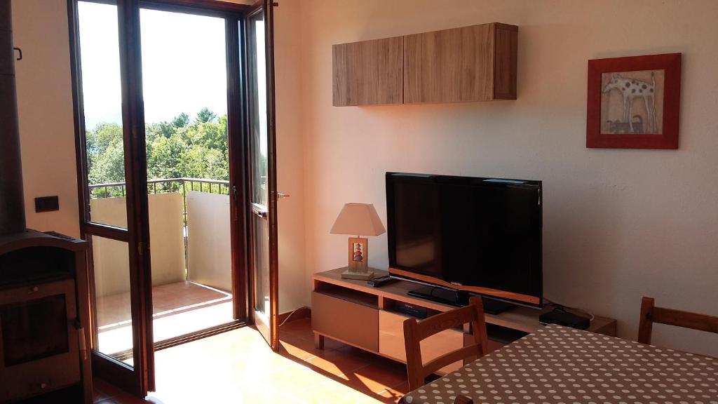 een woonkamer met een televisie en een balkon bij Residenza Paradiso in Agra
