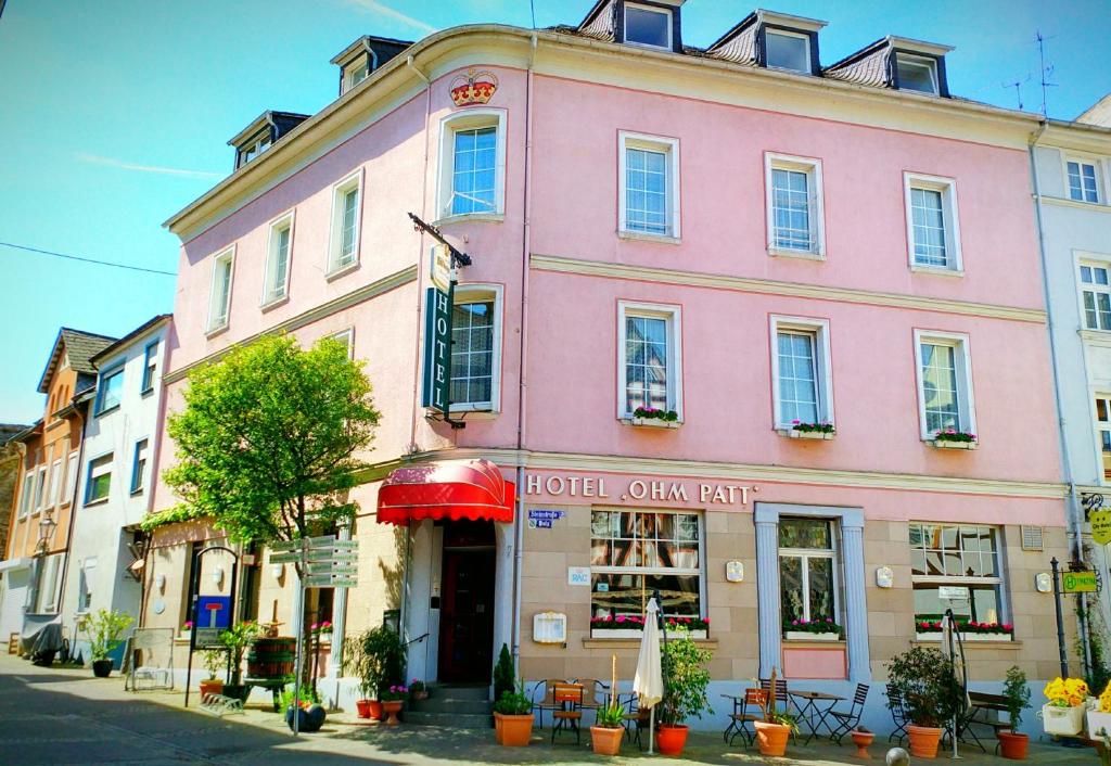 ein rosafarbenes Gebäude an der Straßenseite in der Unterkunft Hotel Ohm Patt in Boppard