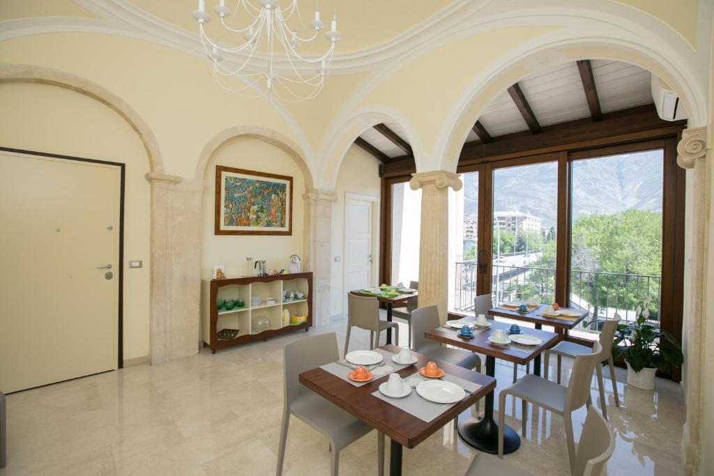 uma sala de jantar com mesas e cadeiras e um lustre em B&B Ponte Capograssi em Sulmona