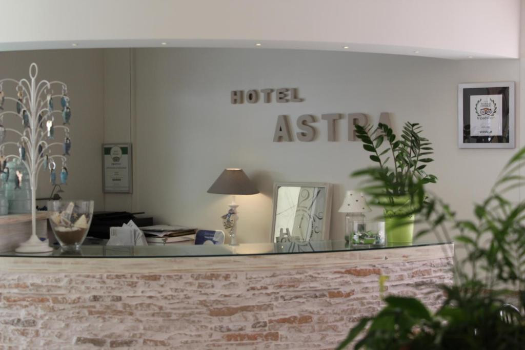un bancone del negozio con un cartello che legga l'assistente dell'hotel di Hotel Astra a Cattolica