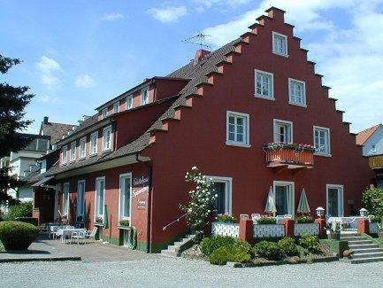 ein großes rotes Gebäude mit Balkon auf einer Straße in der Unterkunft Gästehaus Sparenberg in Bad Krozingen