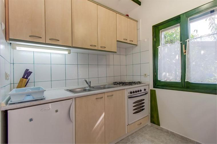 eine Küche mit einer Spüle, einem Herd und einem Fenster in der Unterkunft Apartment Julia in Veli Lošinj