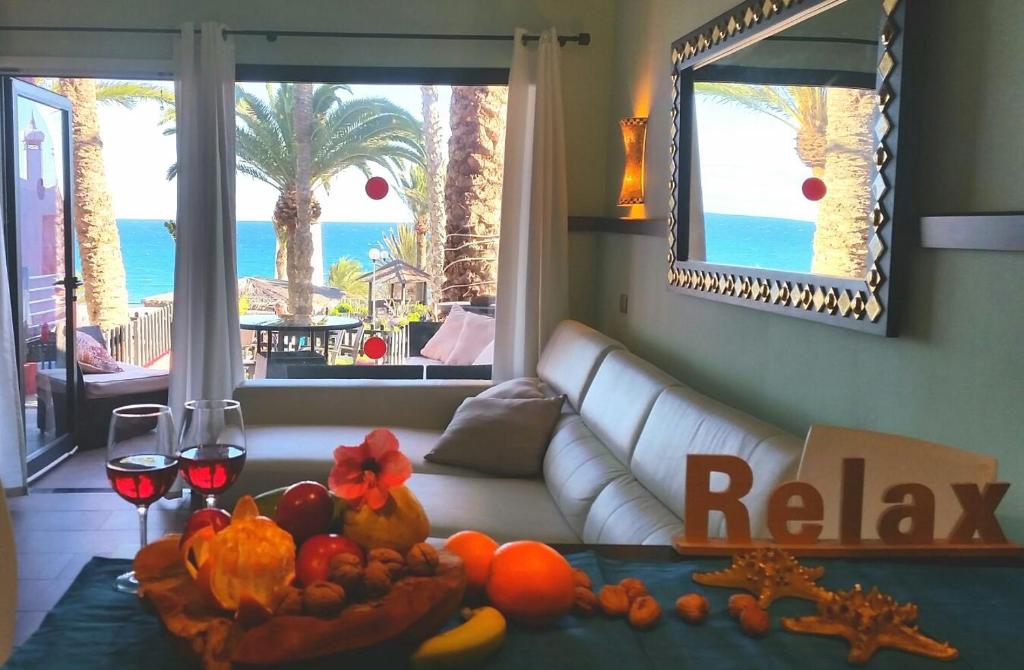 Playa del AguilaにあるFirst line ocean bungalowのリビングルーム(白いソファ、フルーツ付きのテーブル付)
