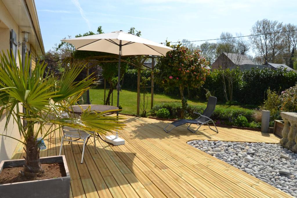 une terrasse avec un parasol, des chaises et une table dans l'établissement L'ESCALE, à Allenay